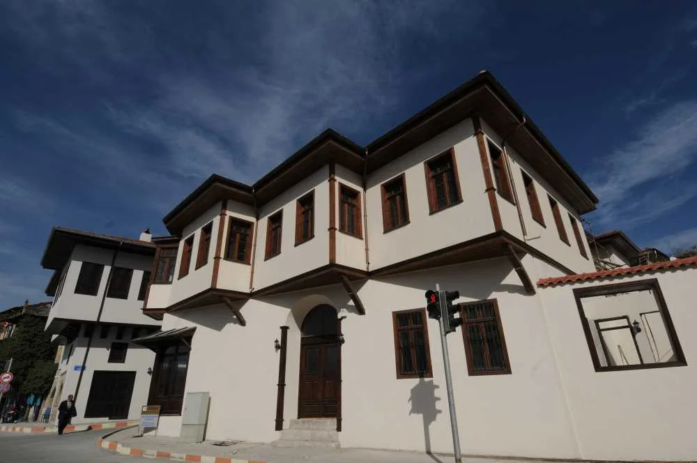 Modern ve Gelenekselin Buluşması - Piribaşlar Kültür ve Sanat Evi Açık beyaz duvarlar ve koyu ahşap çerçevelerle iki katlı geleneksel yapı