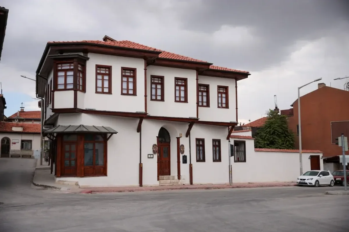 Piribaşlar Kültür ve Sanat Evi - Tarihi Mirasın Beyaz Cephesi Beyaz dış cepheli tarihi bina, ahşap çerçeve pencereler ve kırmızı kiremit çatı ile dikkat çekiyor.