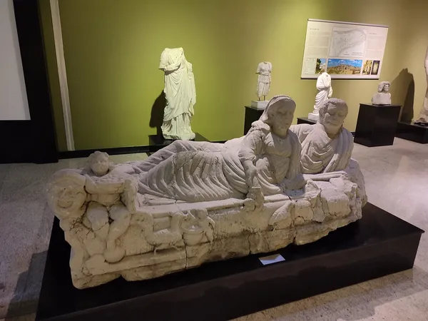 Antik heykel grubunda divanda oturan erkek ve kadın figürleri, yanında çocuk figürüyle sergileniyor.