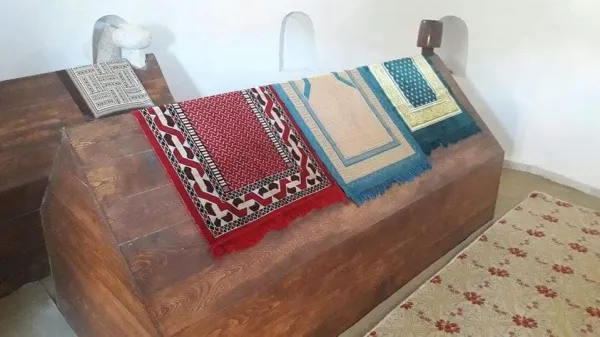 Ahşap yüzeyde çeşitli desenlerde örtüler ve çiçek desenli halı