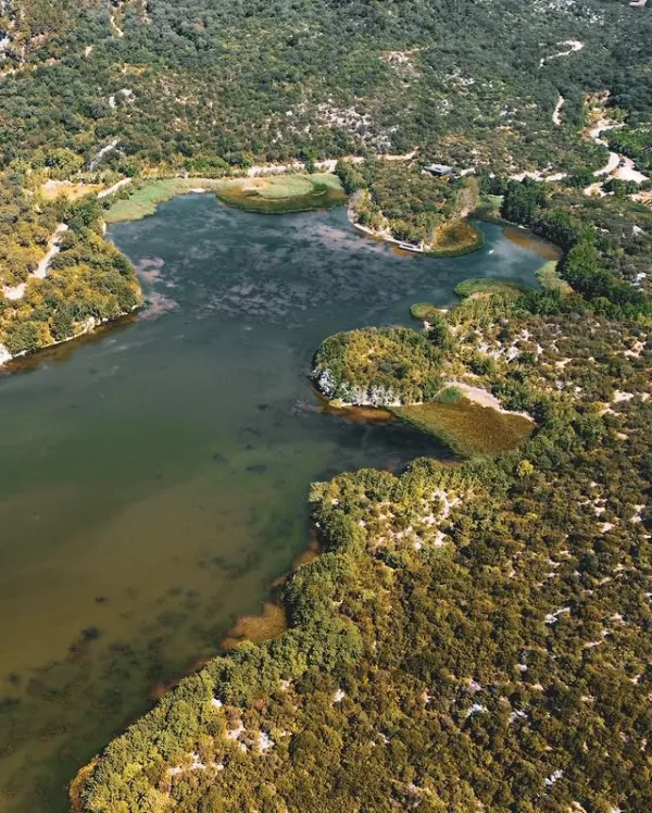 Yemyeşil ormanlarla çevrili sakin bir göl ve çevresindeki adacıklar
