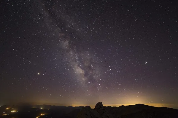 Yıldızlarla dolu gökyüzü ve karanlık dağ silüetleri ile Melikler Yaylası'nın gece manzarası.