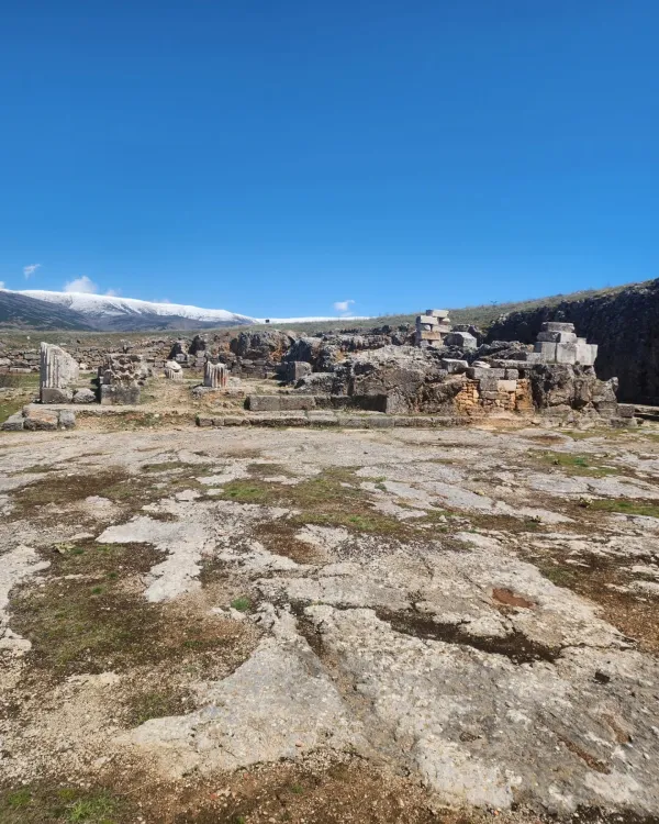 Geniş alanda tarihi kalıntılar ve karla kaplı dağlar görünmekte.