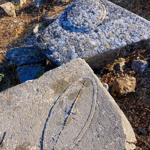 Büyük taş bloklar, izler ve doğal ortamla tarihi kalıntıları yansıtıyor.