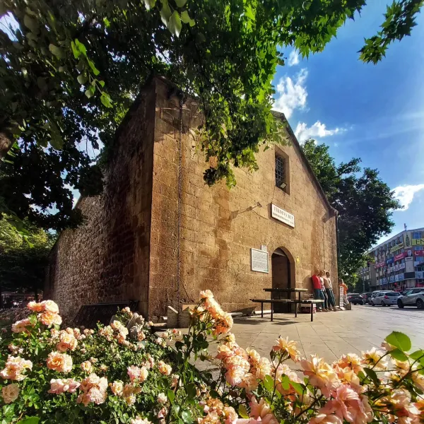 Tarihi Firdevs Bey Camii, pembe güllerle çevrili taş yapısıyla dikkat çekiyor.
