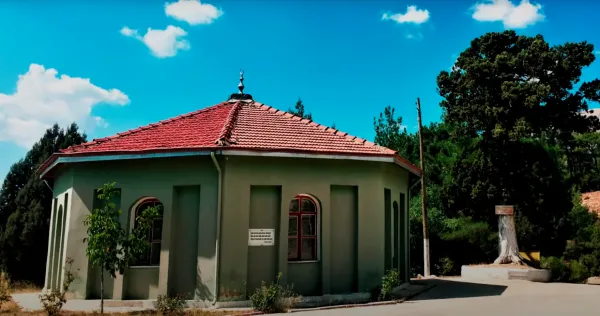 Sekizgen yapıda yeşil dış cephe, kırmızı çatı ve renkli pencereler bulunuyor.