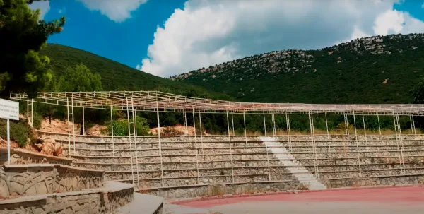 Yarım daire amfi tiyatro, arka planda yeşil dağlar ve mavi bulutlar