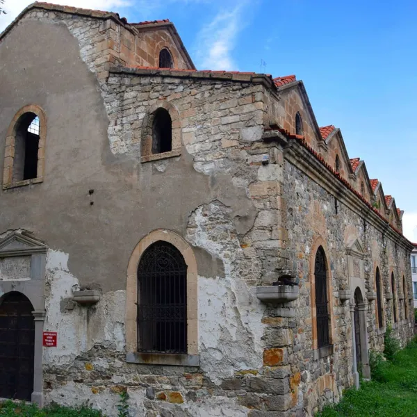 Tarihi bir kilisenin dış cephesi, hasar görmüş taş yapısı ve mavi gökyüzü