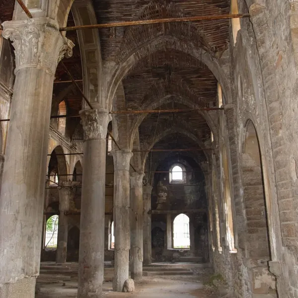 Terkedilmiş Aya Payana Kilisesi'nin iç mekanında büyük sütunlar ve loş ışık