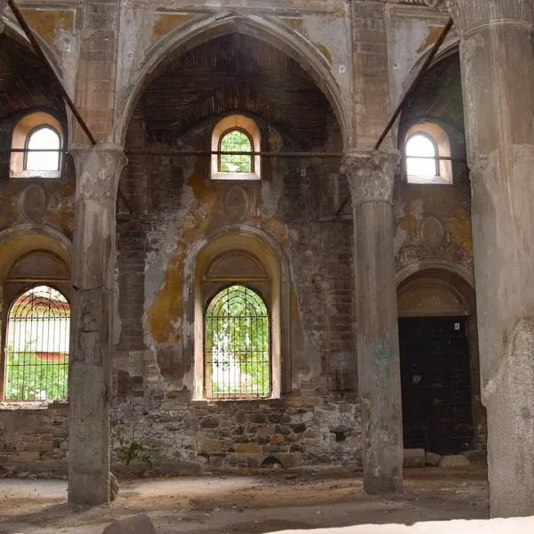 Yüksek kemerler ve demir parmaklıklarla süslü tarihi kilise içi.
