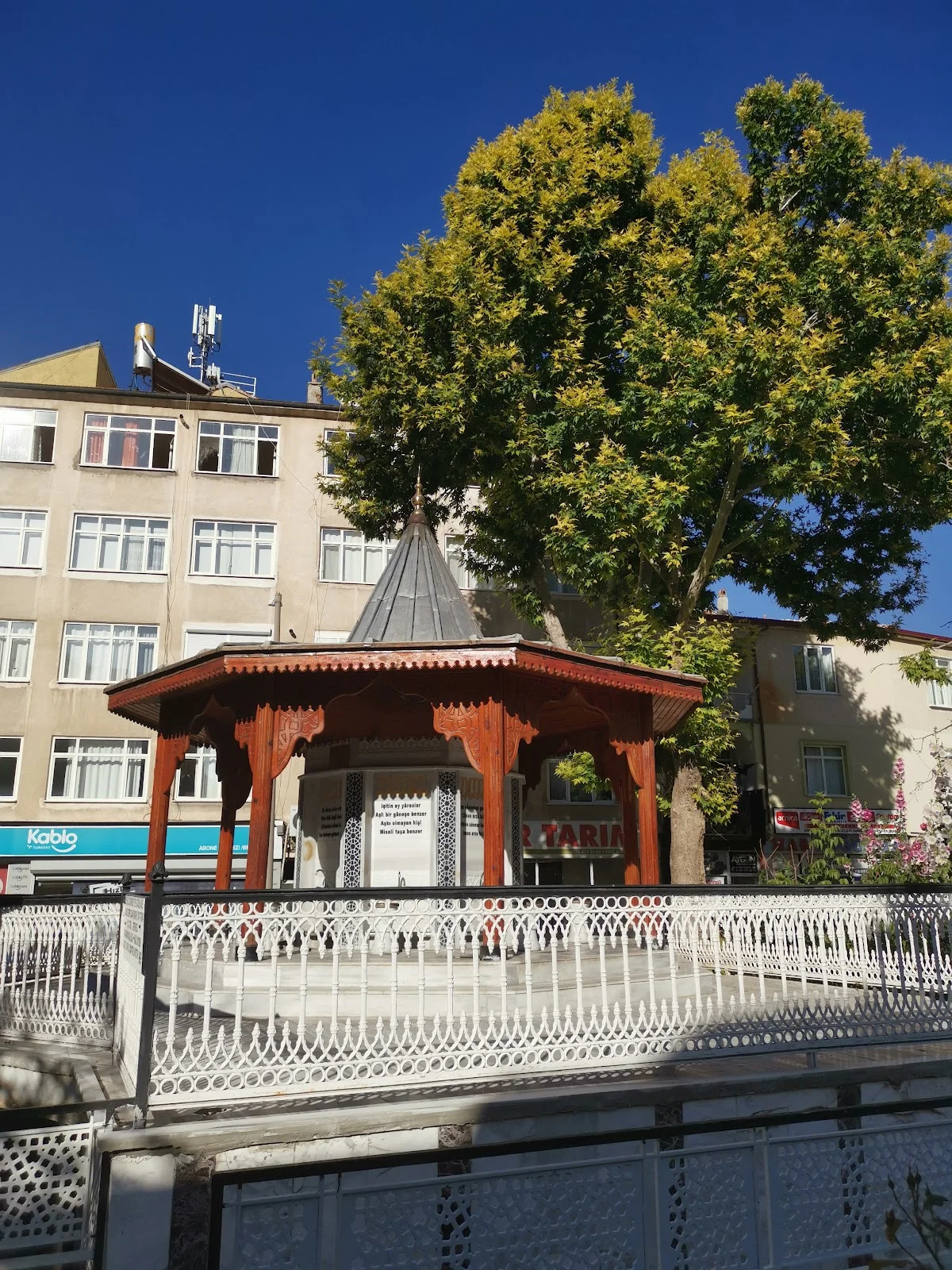 Ahşapta Tarih - Motiflerle Bezenmiş Yunus Emre Türbesi Ahşap türbe, geleneksel Türk motifleriyle süslenmiş ve çevresinde ağaçlar var.