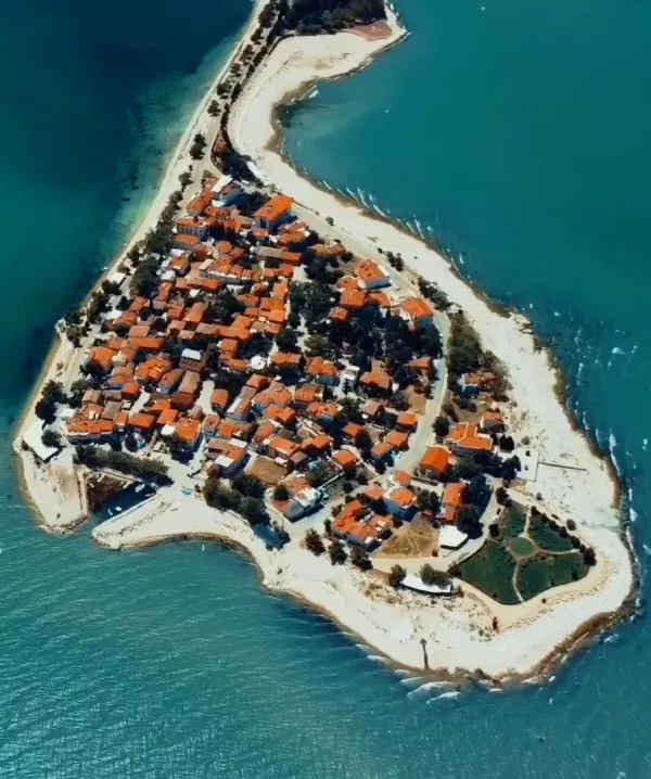 Denizle çevrili yarımada, beyaz duvarlı evler ve turkuaz deniz