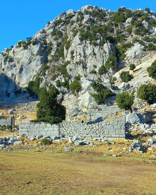 Kapıkaya Antik Kenti'nin koyu gri taşlardan yapılmış kalıntıları ve doğal peyzajı.