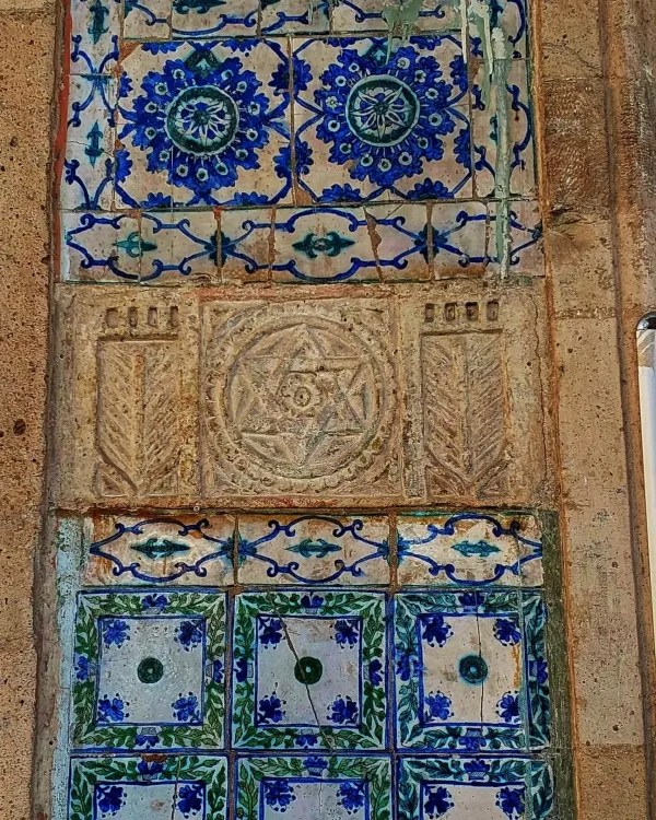 Çiçek desenleriyle süslenmiş büyük ve küçük seramik karoların yer aldığı, geleneksel tasarıma sahip bir yüzey