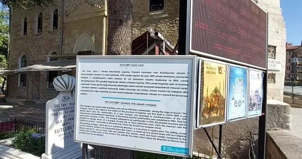 Kutlu Bey Camii'nin bilgilendirme tabelası ve tarihi taş yapısı.