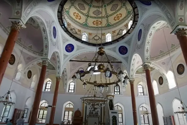 Yüksek tavan, gösterişli avize ve detaylı süslemelerle Kutlu Bey Camii içi