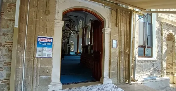 İşlenmiş kapı ile mavi halı kaplı iç mekan ve süslü tavan görünümü