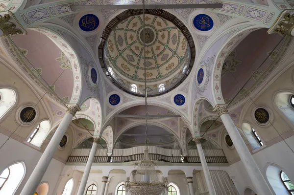 Kutlu Bey Camii'nin iç mekanında yüksek kubbe ve altın kaligrafi süslemeleri görülüyor.