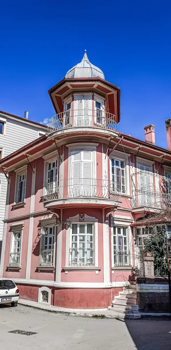 Pembe dış cepheli iki katlı Osmanlı tarzı bina, konik çatı ve geniş pencerelerle dikkat çekiyor.