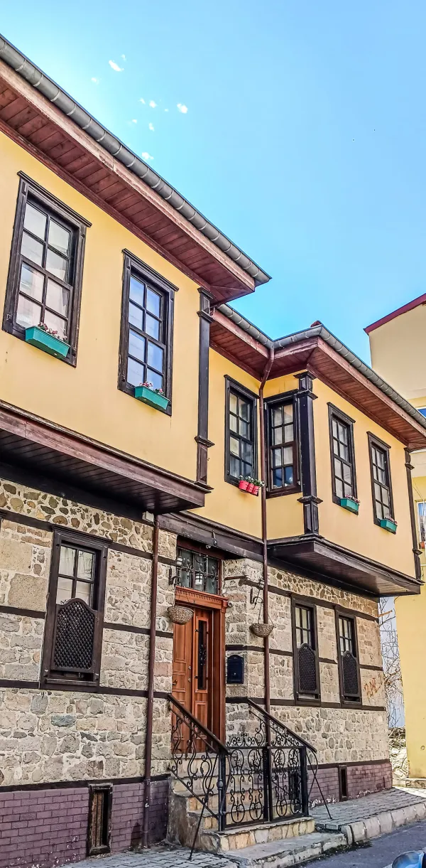Geleneksel ahşap detaylarla zenginleşmiş tarihi bir Isparta evi ön cephesi.