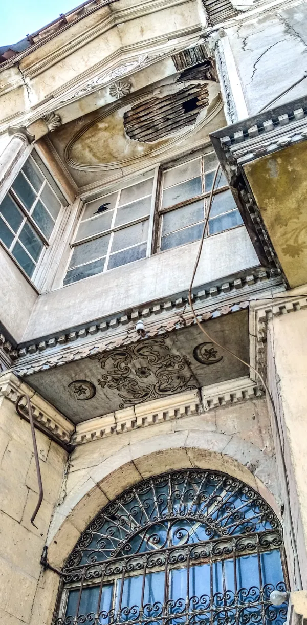 Eski binanın oymalı süslemeleri ve çatlamış pencereleri