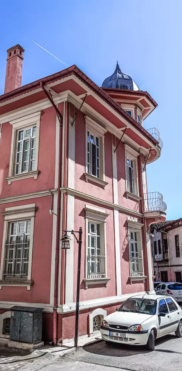 Pembe renkli tarihi bina, bol pencereli ve yuvarlak çatıyla dikkat çekiyor.