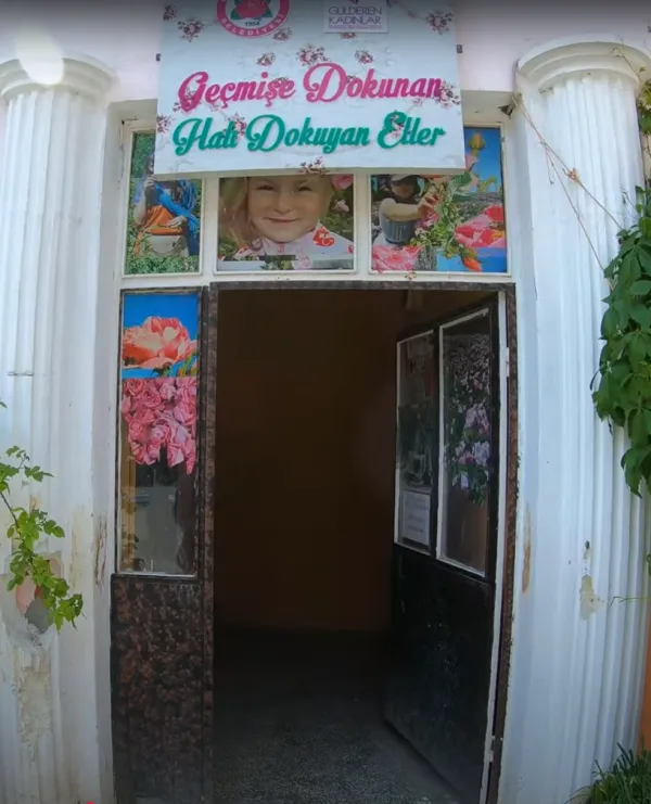 Güneykent kasabası giriş kapısı, üstünde tabela ve renkli süslemelerle çevrili.