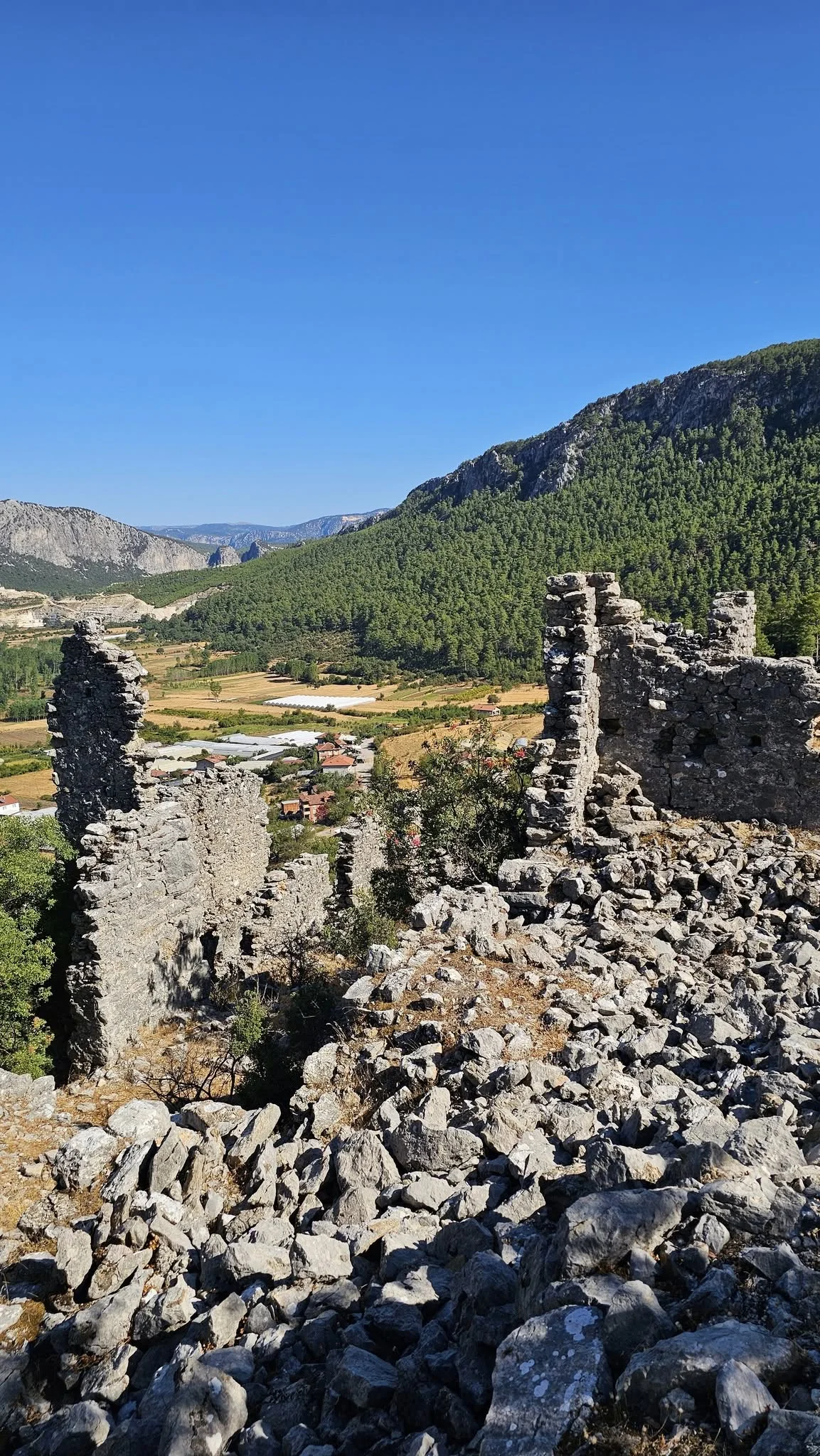 Dağlık alanda harabe kalıntıları, yemyeşil orman ve tarım arazileri