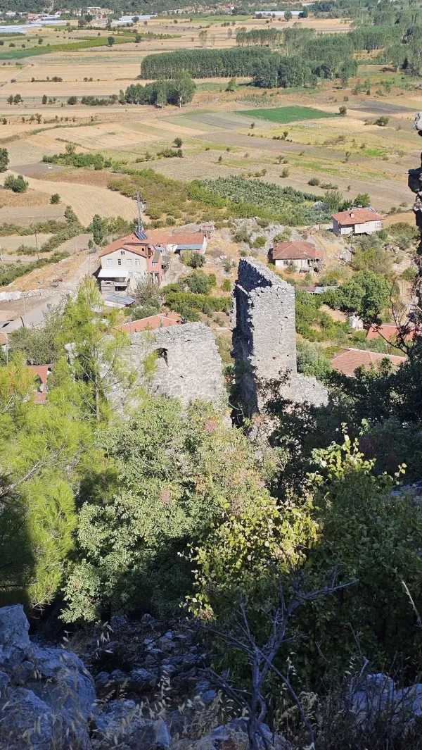 Eski taş kalıntıları, çevresinde yeşil alanlar ve kırmızı çatılı evler