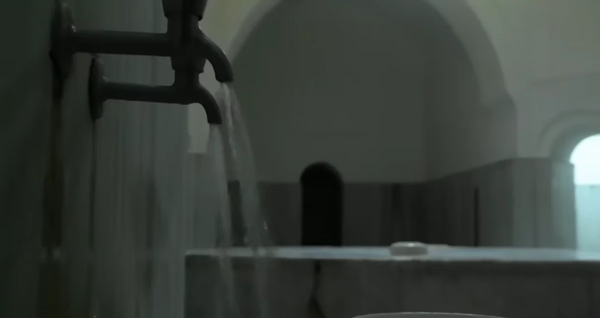 Tarihi Dalboyunoğlu Hamamı - Huzur ve Tarihin Kesişimi! Eski tarz hamamda akan su, mermer yapılar ve loş ışık ortamı.