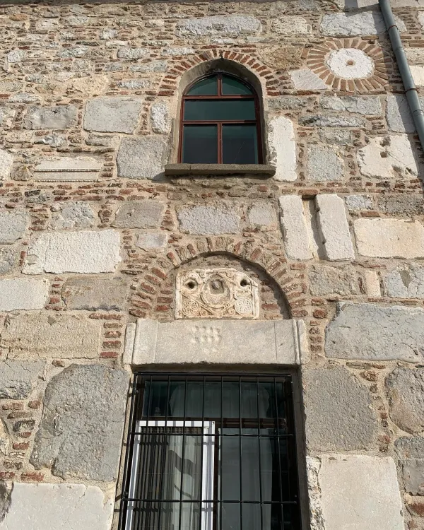 Tarihi Devlethan Camii'nin taş duvarları ve kemerli penceresi detaylarıyla görünüyor.
