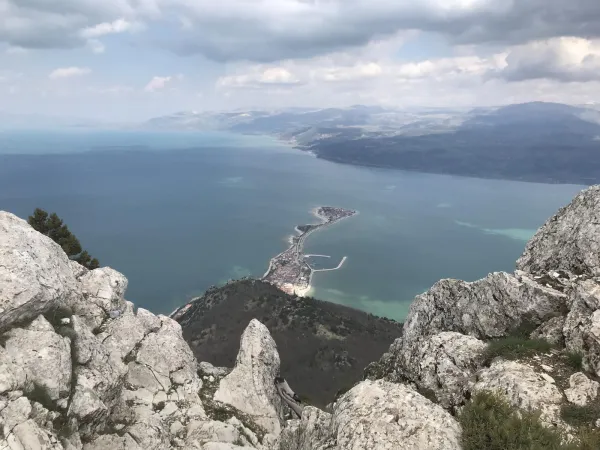 Yüksek dağ zirvesinden görülen mavi suyla çevrili yarımada ve plajlar