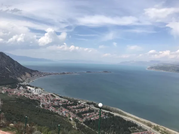 Sakin bir tatil beldesinde yeşil ağaçlar ve mavi deniz manzarası