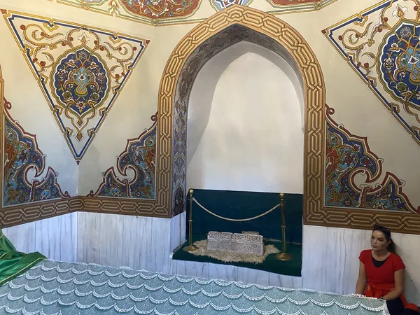 Zengin Osmanlı motifleriyle süslenmiş iç mekan ve kadın ziyaretçi.