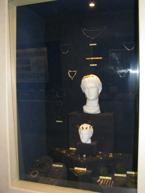 Isparta Müzesi'nde vitrin içinde beyaz heykel başı ve antik takılar sergileniyor.