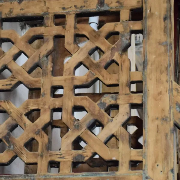 Karmaşık geometrik desenlere sahip üst üste binen ahşap yapı görünmektedir.