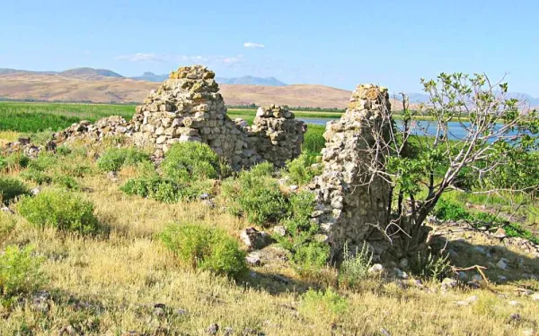 Yıkık taş duvarlar, doğal bitki örtüsü ve sakin su yüzeyiyle Limenia Adası manzarası