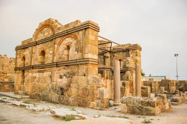 Eski men tapınağının kalıntıları, taş duvarlar ve sütunlar ile çevrili.