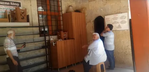 Abdülgaffar Camii'nin iç mekanında oturan erkekler ve dekoratif objeler