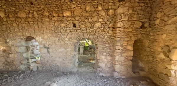 Tarihi taş yapının iç mekanı, duvarlar büyük doğal taşlardan yapılmış ve doğal ışık alıyor.