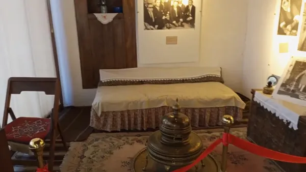 Tarihi bir iç mekan, ortada ocak, geleneksel halı, eski mobilyalar ve nostaljik atmosfer