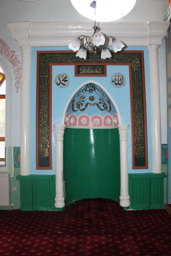 Dalboyunoğlu Camii'nin yeşil kapısı ve açık mavi duvarlarıyla iç mekânı