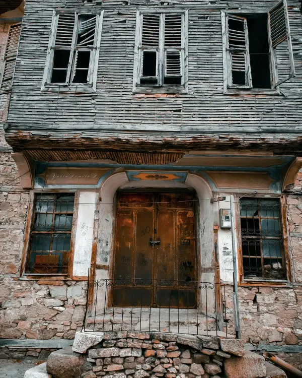 Zamanla bozulmuş tarihi bina, ahşap üst kat ve taş alt kat ile dikkat çekiyor.