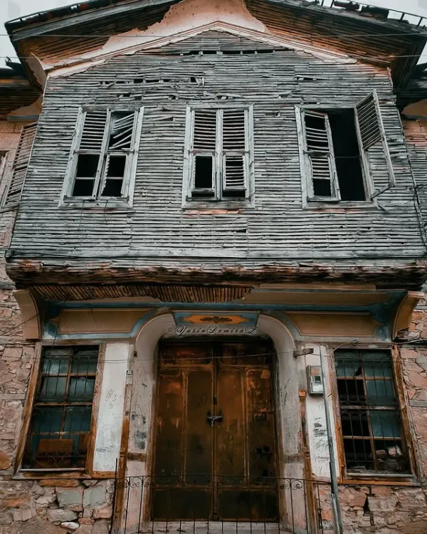 Ahşap ve taş malzemeden inşa edilmiş terkedilmiş bir yapının ön cephesi