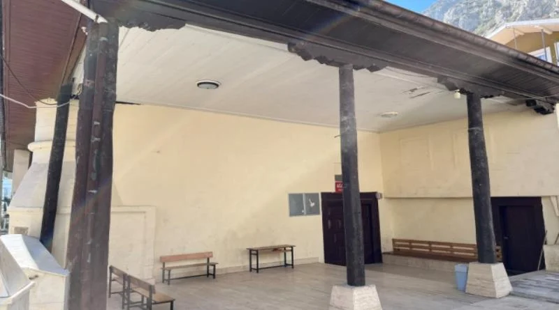Merkez Ağa Camii'nin iç mekanında yüksek beyaz tavan ve ahşap masalar görünmektedir.