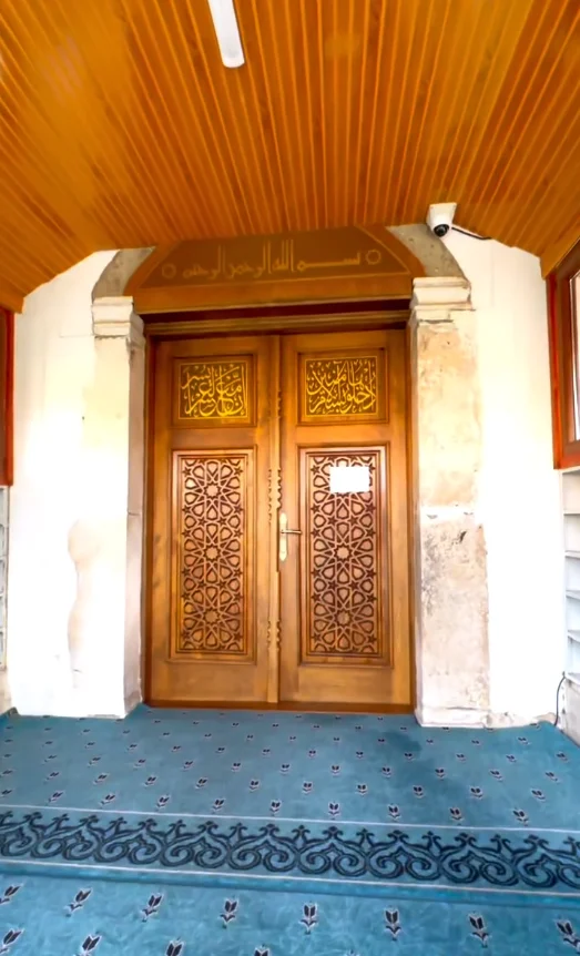 Feyzullah Paşa Camii giriş kapısı, ahşap işçilik ve Arap harfleriyle süslenmiş