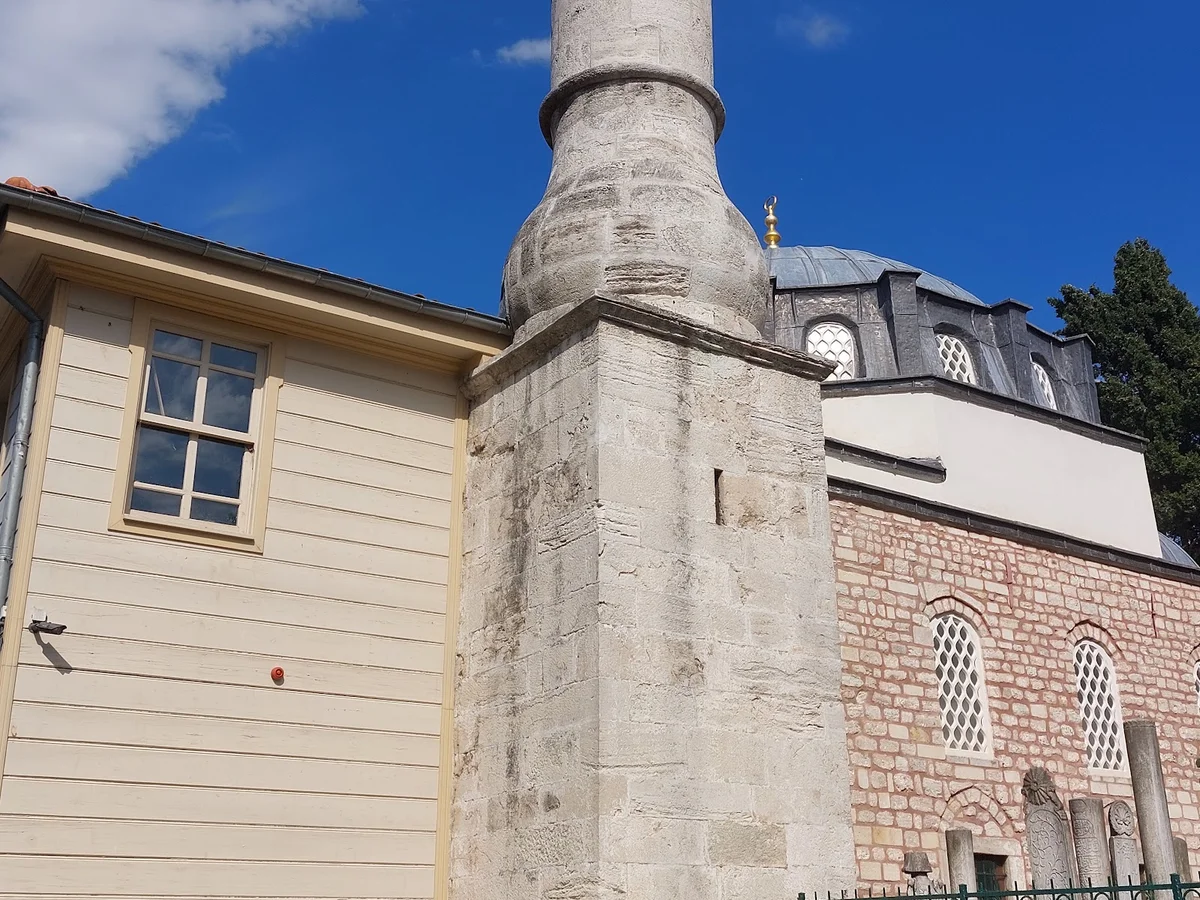 Beyaz ahşap yapı ve pembe-gri taşlardan oluşan cami mimarisi