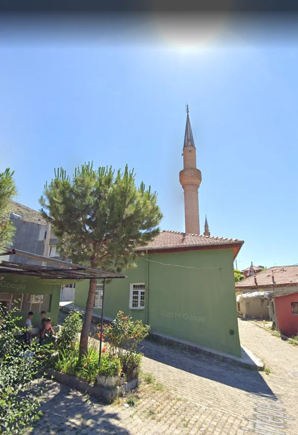 Yeşil binanın yanında, ince minaresi ile Şeyhler Camii ve mavi gökyüzü