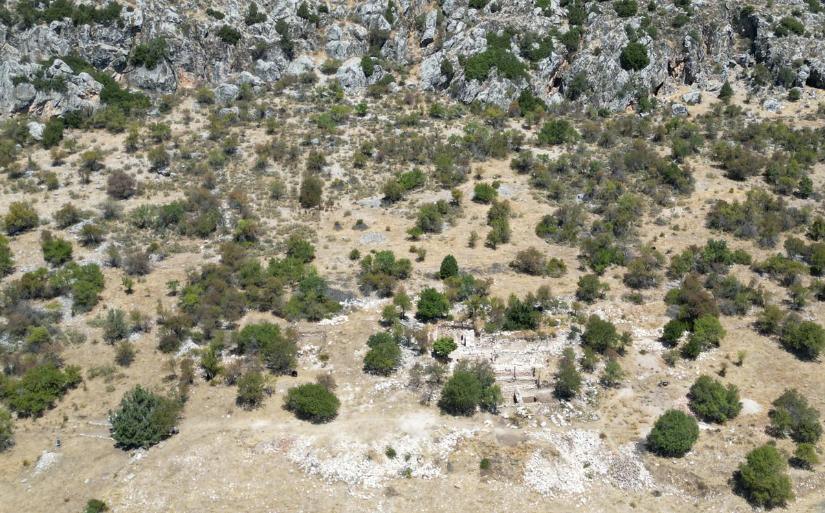 Yeşil bitki örtüsü ve tarihi kalıntılarla doğal bir manzara.