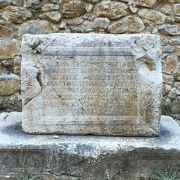 Antik Yunanca metinler içeren taş levha ve arka planda kalıntılar